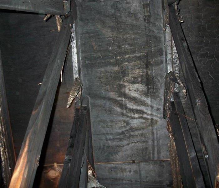 fire-blacked rafters and sheathing in an attic